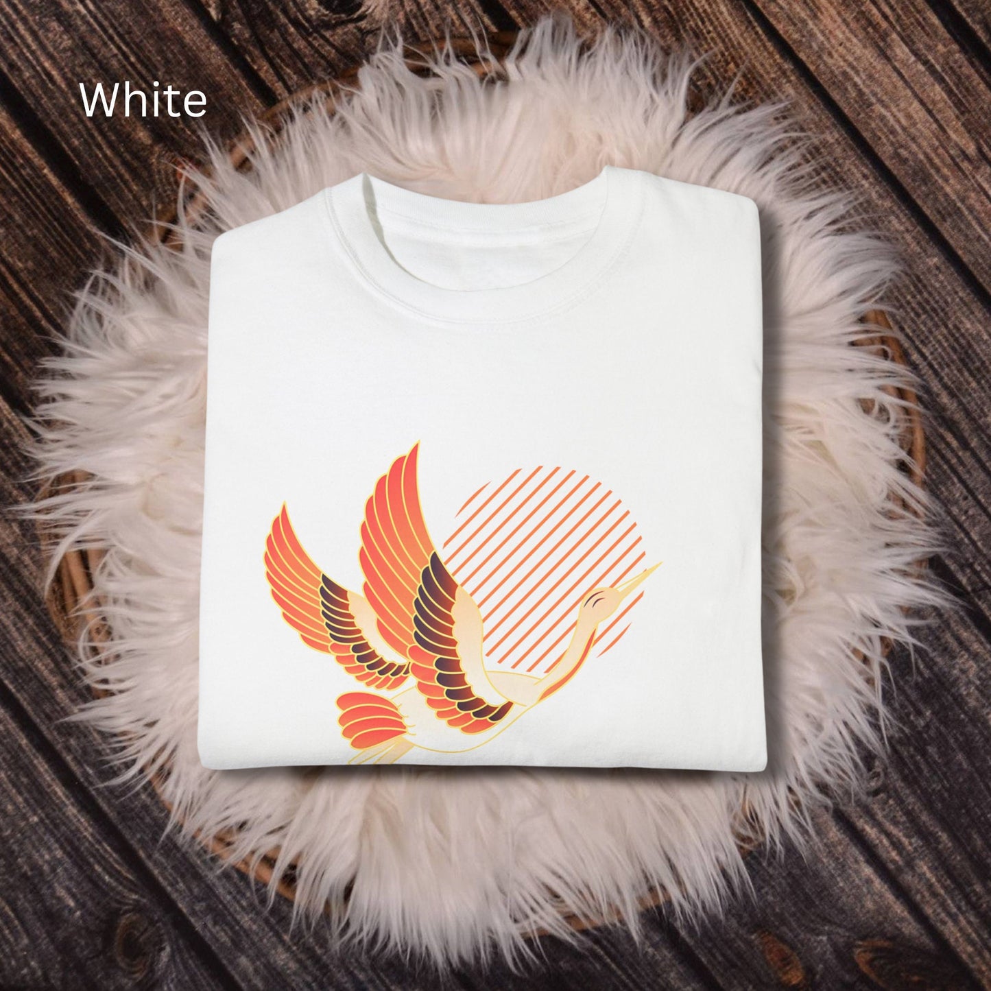 Crew neck white short sleeve T-shirt with a white and orange japanese crane  flying with legs extended behind it in front of diagonal orange lines arranged to make a sun in the middle. Japanese kanji symbol for happiness below the crane on the left.