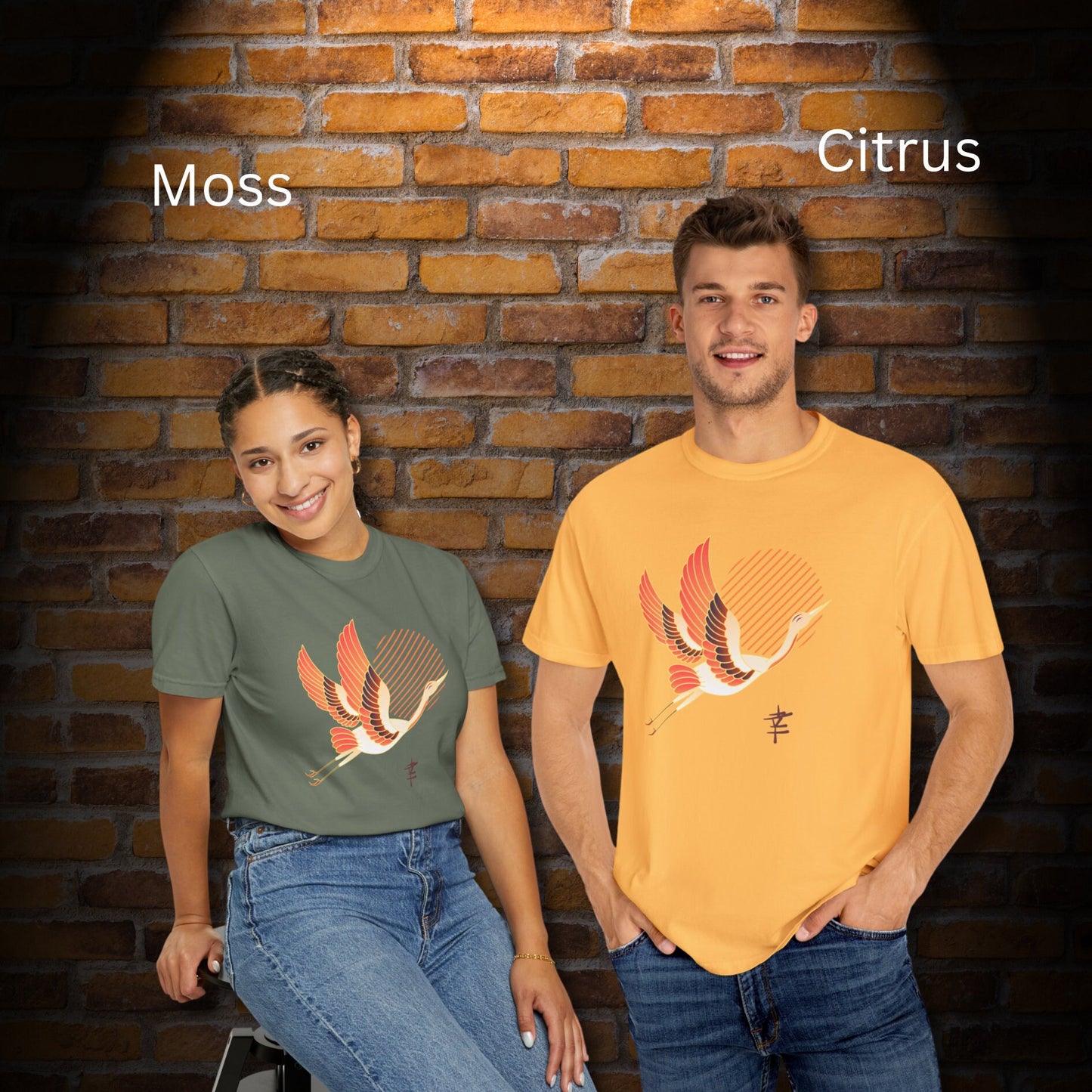 Crew neck Moss & Yellow short sleeve T-shirts with a white and orange japanese crane  flying with legs extended behind it in front of diagonal orange lines arranged to make a sun in the middle. Japanese kanji symbol for happiness is bottom left